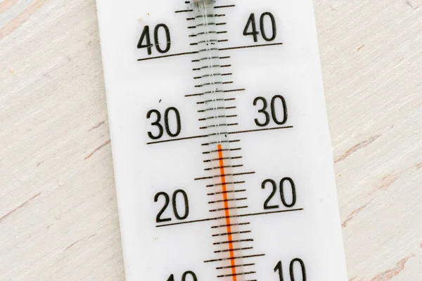 Extreme close up macro of white plastic thermometer scale on wooden surface — Stock Photo, Image