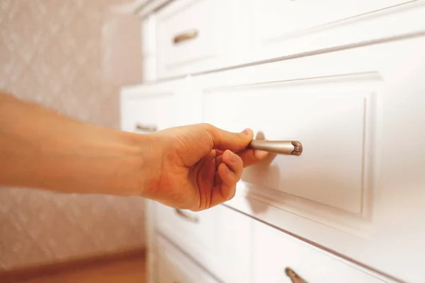Close up person hand opens wooden shelf at home — Stock Photo, Image