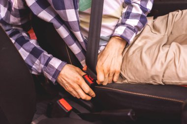 Genç erkek sürücünün emniyet kemerini bağlaması, hayat konseptinizi güvene alır.