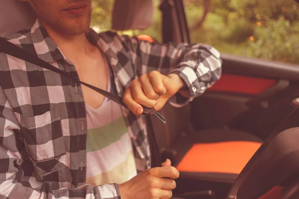 Conductor masculino joven que fija el cinturón de seguridad del coche, seguro su concepto de la vida —  Fotos de Stock