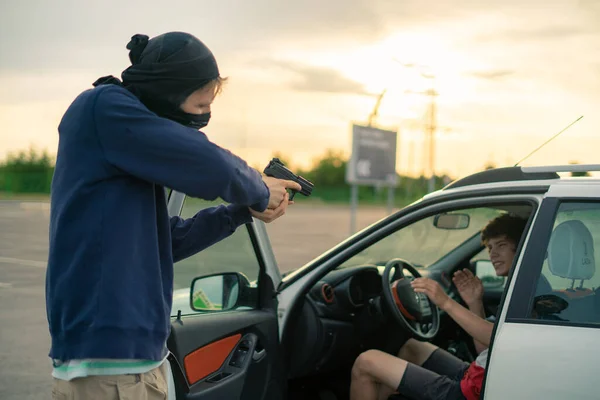 Accidente criminal, ladrón amenazando al conductor del coche con una pistola en el aparcamiento —  Fotos de Stock
