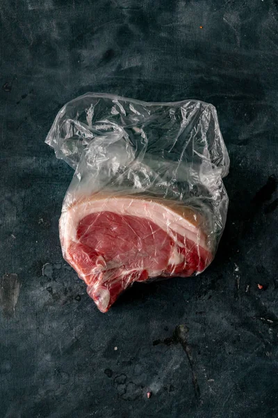 Carne crua sangrenta fresca em um saco de plástico logo após comprá-lo no açougue — Fotografia de Stock