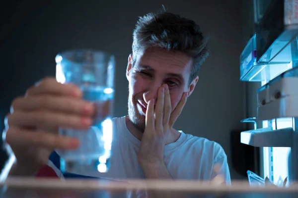 Hungrig man letar efter ett mellanmål i kylskåpet på natten, utsikt från kylskåpen — Stockfoto