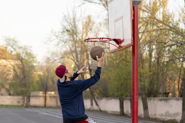 Basketbolcu şehir kortlarında atış talimi yapıyor.