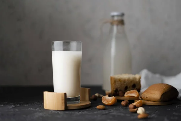 Glass of nut healthy milk without harmful fats on a grunge surface, profitable dinners — Stock Photo, Image