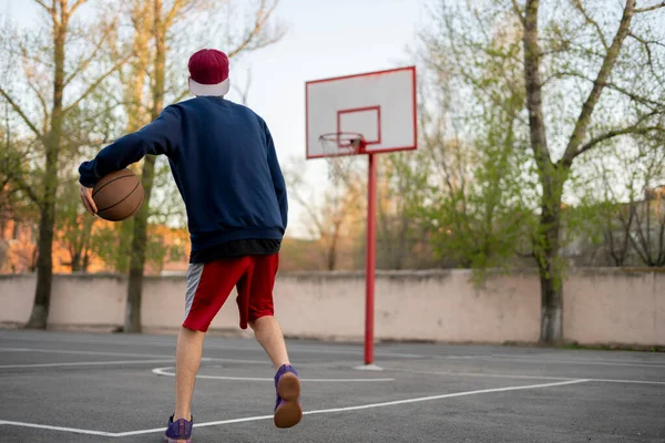 Młody koszykarz trening dryblować na zewnątrz na boisku asfaltowym w sezonie letnim — Zdjęcie stockowe
