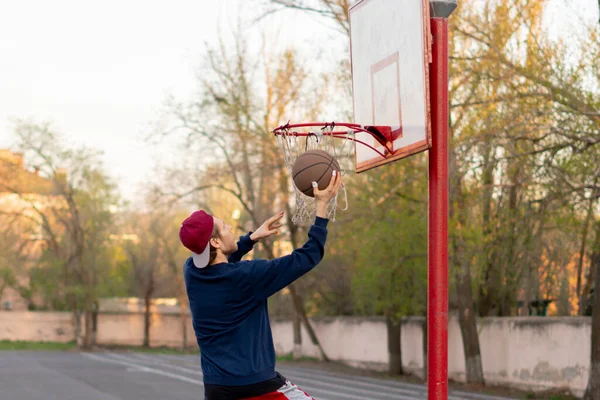 Jogador de basquete fazendo exercícios de tiro prática ao ar livre nas quadras de rua da cidade — Fotografia de Stock
