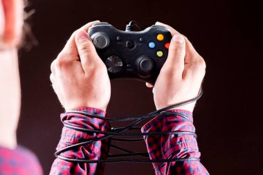 Oyun bağımlılığı konsepti b, insanların ellerine sarılı joystick kablosu
