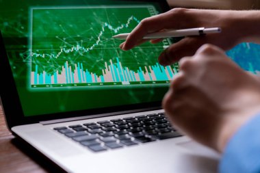 Genç bir işadamı aletleriyle hisse senetlerini izliyor.