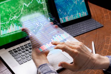 Genç bir işadamı aletleriyle hisse senetlerini izliyor.