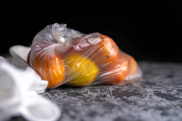 Frutas estropeadas dañadas en una bolsa en una habitación oscura, concepto de daño de contenedor de plástico b — Foto de Stock