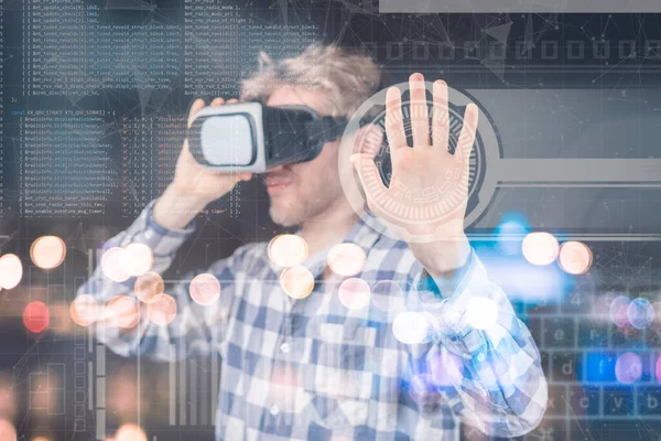Fiatal férfi virtuális szemüvegben dolgozik grafika, hologram körülötte, futurisztikus eszközök koncepció b — Stock Fotó