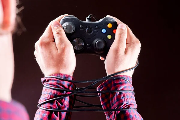 Joystick wire wrapped around persons hands, video games addiction concept b — Stock Photo, Image
