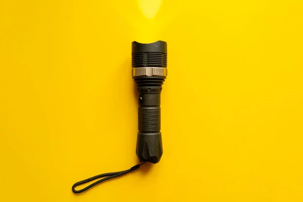 Steel torch isolated on yellow surface, producing light beams or rays, copy space b — Stock Photo, Image