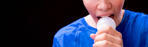 Смешной молодой человек ест лампочку, шутки концепции, смешные ребята