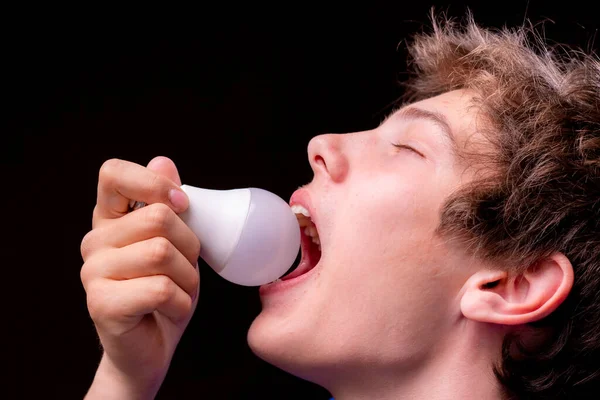 Jovem engraçado comer lâmpada, conceito de piada, caras engraçados — Fotografia de Stock