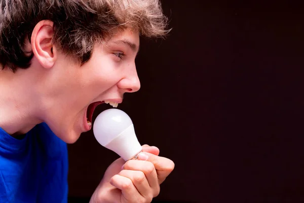 Lustige junge Mann essen Glühbirne, Witz Konzept, lustige Jungs — Stockfoto