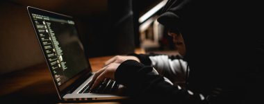 Erkek hacker dizüstü bilgisayar kullanıyor, devlet sunucularını kişisel verilerle kırıyor