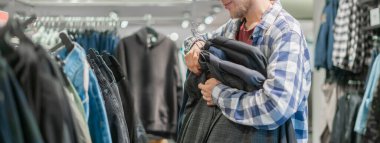 Bir butikte yepyeni giysileri olan stresli bir insan.