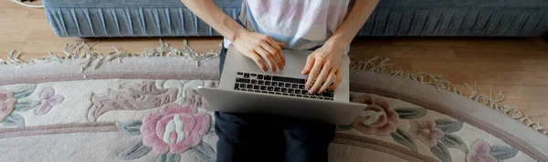 Jongeman zitten op de vloer thuis en werken met zijn laptop b — Stockfoto