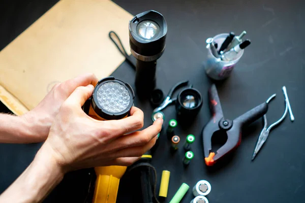 Personnes mains tenir une lampe de poche dans un atelier b Photo De Stock