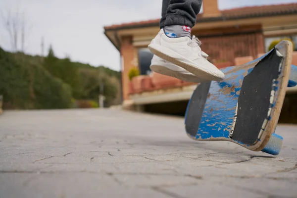 アスファルトパス上のみすぼらしいスケートボードに乗るスニーカーのクロップ — ストック写真