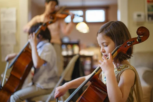 Uma Criança Pequena Toca Violoncelo Com Sua Família Sala Estar — Fotografia de Stock