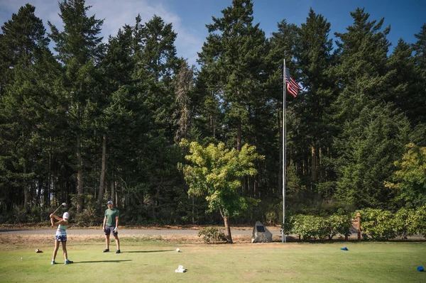 Junges Mädchen Golfabschlag Schwingt Golfschläger Während Mann Sonnigem Tag Zuschaut — Stockfoto
