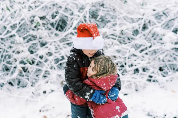 Małe Dzieci Bawiące Się Podczas Opadów Śniegu Zewnątrz Czapce Mikołaja — Zdjęcie stockowe