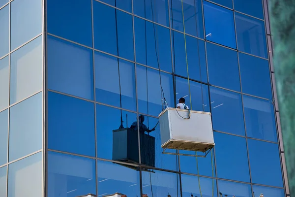 西班牙潘普洛纳 一名工人正在清洗一座现代玻璃建筑的窗户 — 图库照片