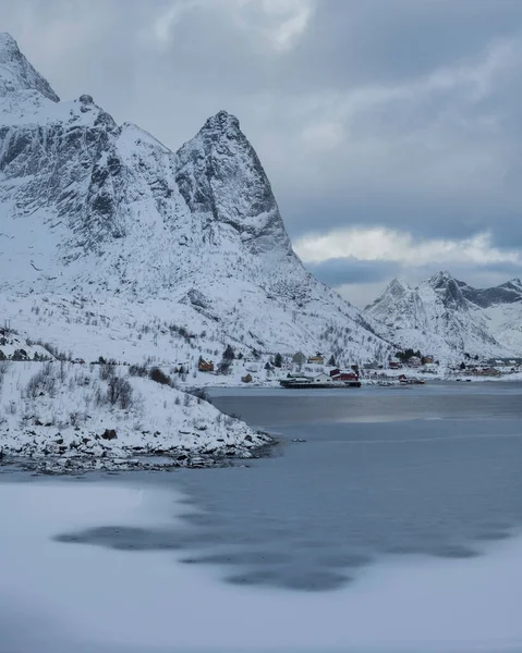 登山者在挪威罗浮敦群岛Reine港口冰封的海湾上方升起 — 图库照片