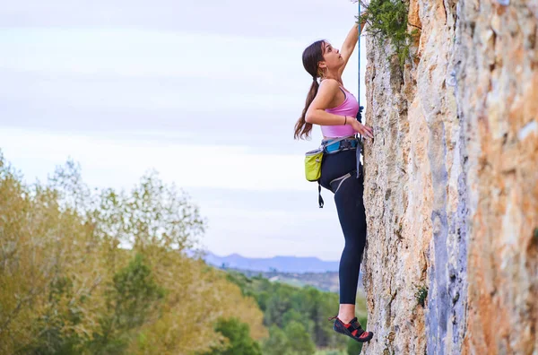 Φωτογραφία Προφίλ Μιας Νεαρής Γυναίκας Που Σκαρφαλώνει Απόκρημνο Βράχο — Φωτογραφία Αρχείου