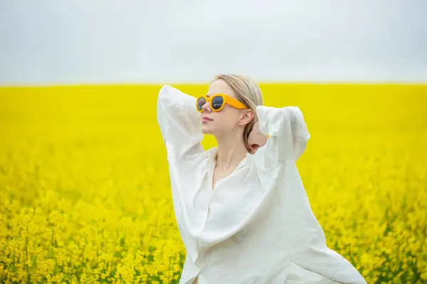 Loira Bonita Óculos Sol Amarelos Camisa Branca Campo Colza Amarelo — Fotografia de Stock