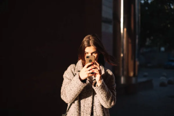 站在城里拿着智能手机的年轻女人 — 图库照片
