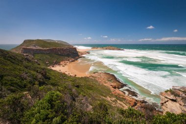 Hint Okyanusu manzarası ve kıyı şeridi Robberg Doğa Rezervi 'nde ahşap patika, Plettenberg Körfezi, Güney Afrika mavi gökyüzüne karşı