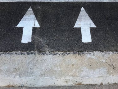 Sokakta beyaz oklar aynı yönü gösteriyor.