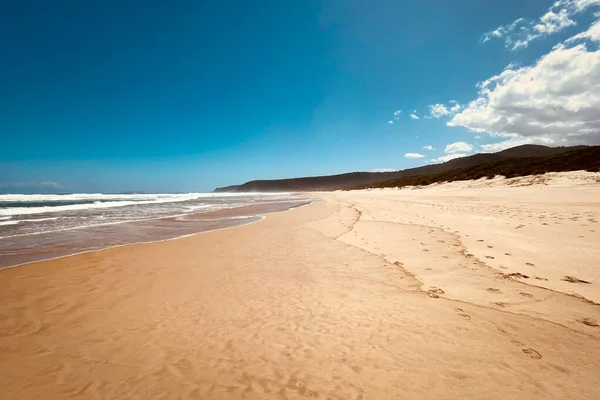 Scenic view of beach in Natures Valley, South Africa with footprints in the sand.