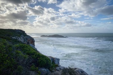 Hint Okyanusu sahillerinin manzarası ve Robberg Doğa Rezervi, Plettenberg Körfezi, Güney Afrika mavi gökyüzüne karşı