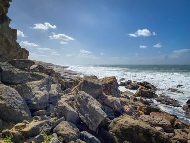Sahne, Hint Okyanusu kıyısında Robberg Doğa Rezervi, Plettenberg Körfezi, Güney Afrika 'da mavi gökyüzüne karşı kayalar.