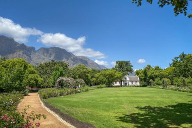 1795 'ten beri Güney Afrika, Franschhoek yakınlarındaki Boschendal Şaraphanesinde bulunan tarihi Rhone Malikanesi' nde Hottentots Holland Dağları mavi gökyüzüne karşı