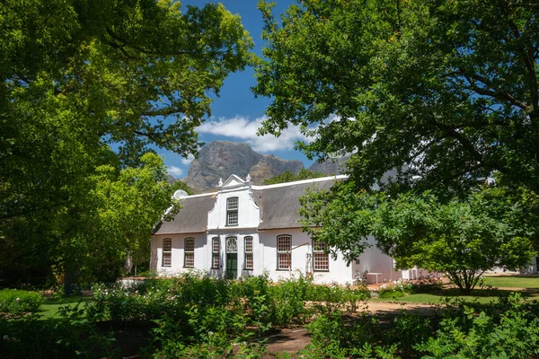 1795 'ten beri Güney Afrika, Franschhoek yakınlarındaki Boschendal Şaraphanesinde bulunan tarihi Rhone Malikanesi' nde Hottentots Holland Dağları mavi gökyüzüne karşı
