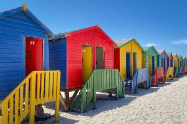Cape Town, Güney Afrika yakınlarındaki Muizenberg 'deki ünlü renkli yazlık evleri mavi gökyüzüne karşı
