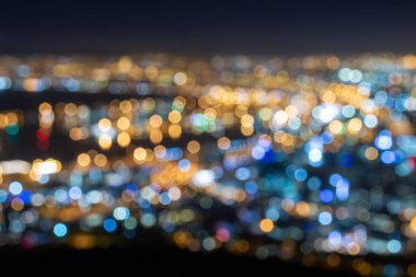 Colorful blurred city lights of Cape Town, South Africa by night against clear sky with alienated colors