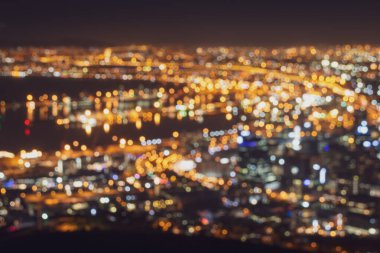 Colorful blurred city lights of Cape Town, South Africa by night against clear sky with alienated colors