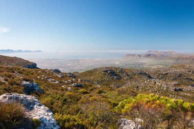 Panoramic view from top of Table Mountain to False Bay and Cape of Good Hope, Cape Town, South Africa in the morning against blue sky