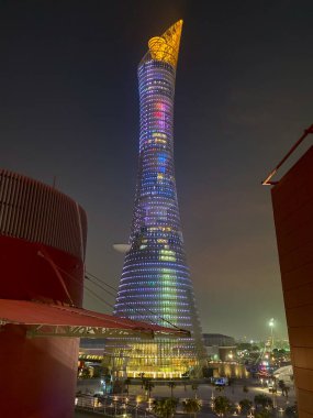 Doha, Qatar  September 26, 2019: The illuminated Torch Tower in Doha Sport City Complex at night against dark sky.