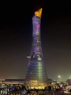 Doha, Qatar  September 26, 2019: The illuminated Torch Tower in Doha Sport City Complex at night against dark sky.
