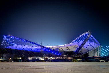 Doha, Qatar  October 1, 2019: Low angle view of colorful illuminated Khalifa International Stadium in Doha at night, Qatar, Middle East against dark clear sky.