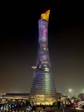 Doha, Qatar  September 26, 2019: The illuminated Torch Tower in Doha Sport City Complex at night against dark sky.