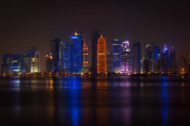 Coloful illuminated skyline of Doha at night, Qatar, Middle East against dark sky